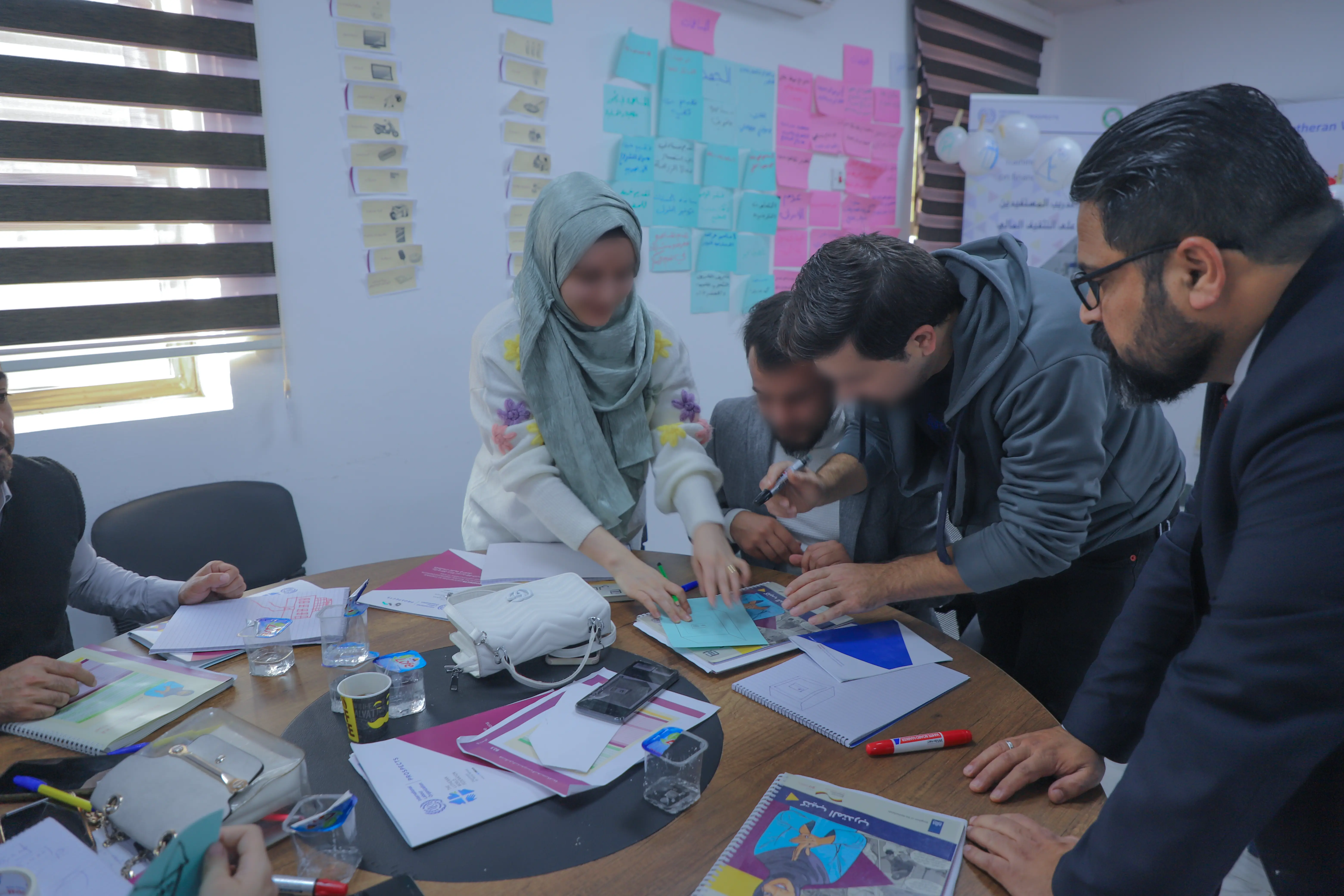 start your business course beneficiaries sitting at tables in al mosul center hall