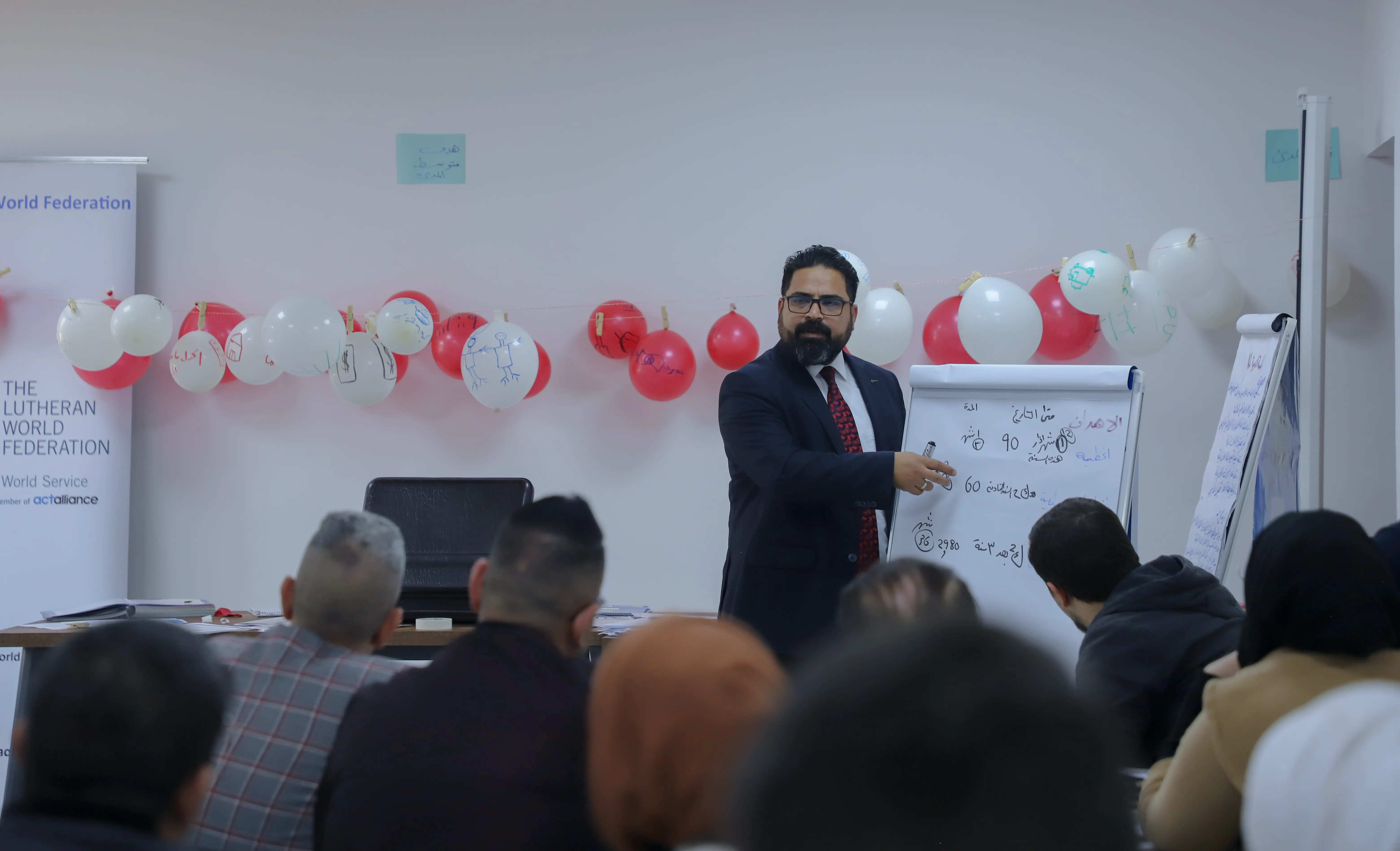 start your business course beneficiaries sitting at tables in al mosul center hall