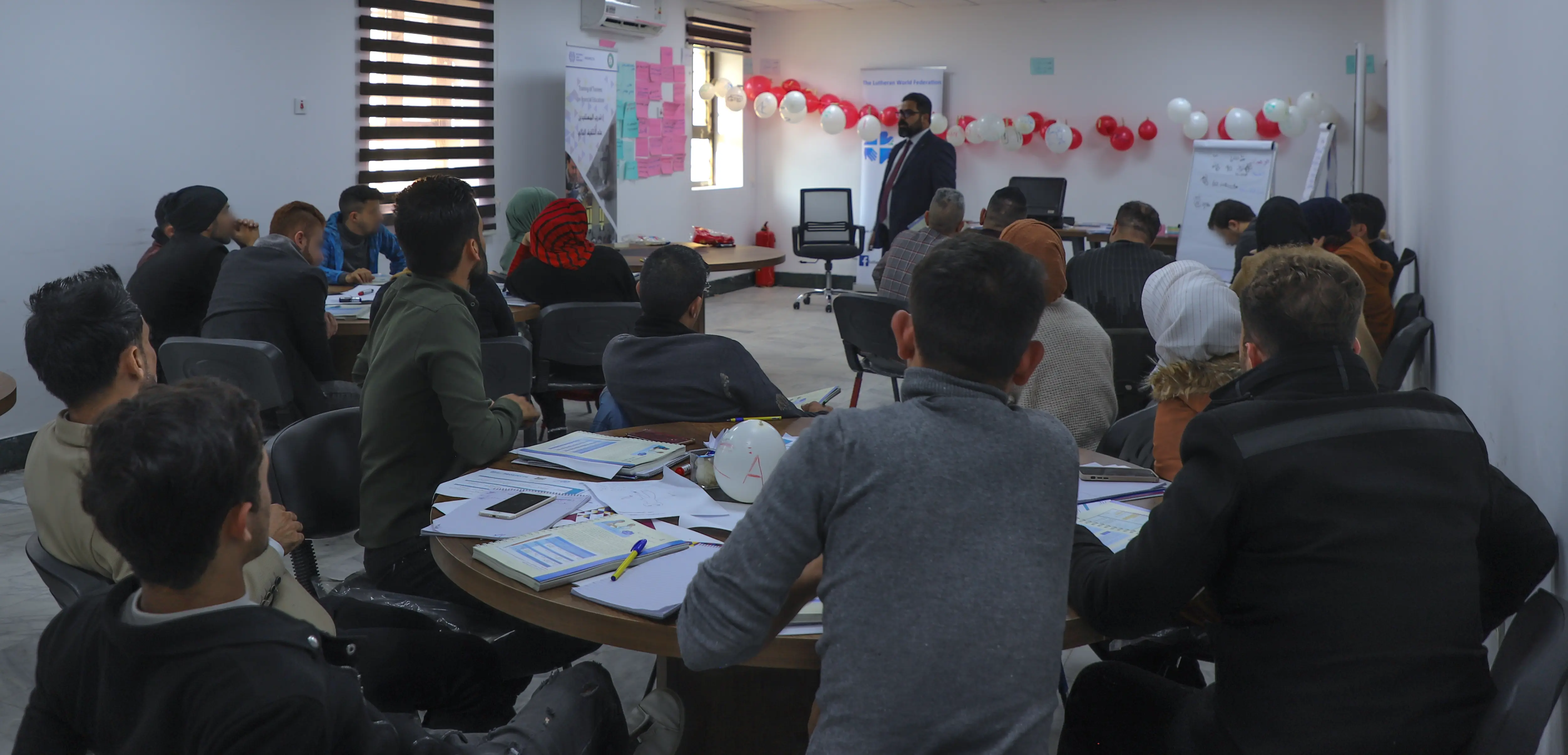 start your business course beneficiaries sitting at tables in al mosul center hall